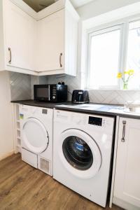 Leverstock GreenにあるCharming flat in Hemel Hempsteadの洗濯機と電子レンジ付きのキッチン +4枚の写真