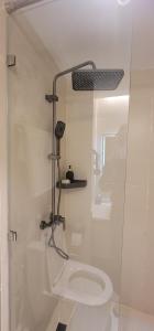 a bathroom with a toilet with a glass shower stall at Acquila Crest by JKIA in Nairobi
