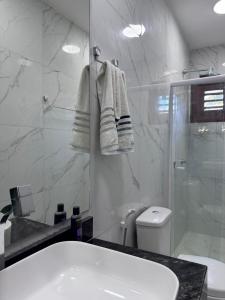 a bathroom with a sink and a shower and a toilet at Belíssima casa na praia do Morro Branco in Beberibe