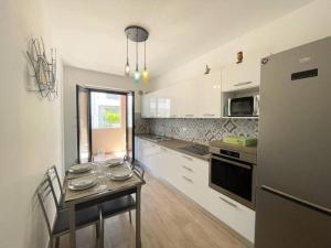 a kitchen with a table and a refrigerator at UNIKO Pineto in Pineto