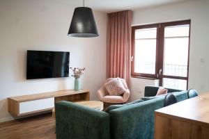 ein Wohnzimmer mit 2 blauen Stühlen und einem Tisch in der Unterkunft Willa Matejki - Apartament 7 in Przemyśl