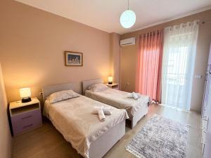a hotel room with two beds and a window at Shkodra Apartments in Shkodër
