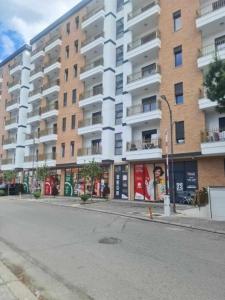 an empty street in front of a large apartment building at S&S City Apartment in Shkodër