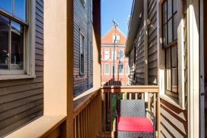 krzesło stojące na ganku pomiędzy dwoma budynkami w obiekcie Downstairs 2BD, Downtown Savannah w mieście Savannah