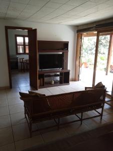 a living room with a couch and a television at Villa Della Pietra in Chaclacayo