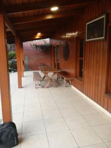 an outdoor patio with a table and a bench at Villa Della Pietra in Chaclacayo