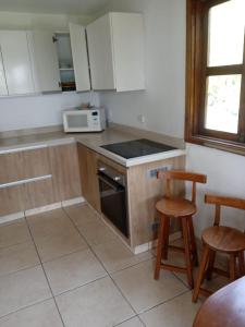 a kitchen with a stove and two stools at Villa Della Pietra in Chaclacayo