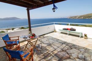 a patio with a table and chairs and the ocean at Thalassia Studios in Kalamitsa