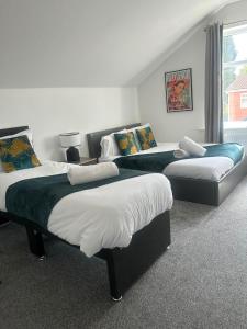 a room with three beds and a couch at Stylish New 4BR - Great for Groups - Free Parking in Leicester