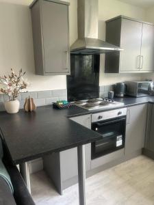 a kitchen with a black counter top and a stove at Stylish New 4BR - Great for Groups - Free Parking in Leicester