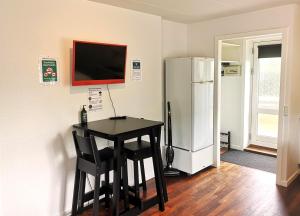 a kitchen with a black table and a refrigerator at H&M Homes Apartments in Aarhus