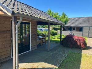 a pavilion with a table under a roof at Klassiek veluws huis onder de beuken in Barneveld