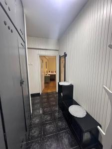 a hallway with a black bench in a room at Апартамент за гости НИКИА в центъра с изглед към Врачанския Балкан Nikia Cityscape & Mountain Escape in Vratsa