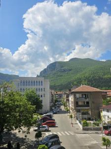 a city street with cars parked in front of a mountain at Апартамент за гости НИКИА в центъра с изглед към Врачанския Балкан Nikia Cityscape & Mountain Escape in Vratsa
