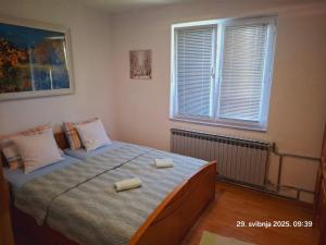 ein Schlafzimmer mit einem Bett und zwei Kissen darauf in der Unterkunft Uma in Bihać
