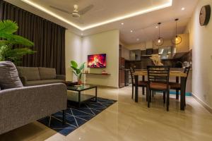 a living room and kitchen with a table and chairs at Luxor Apartments & Suites - Aurum in Lahore