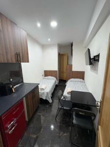 a small room with two beds and a kitchen at Estudios Vistas Playas del Chorrillo in Ceuta +12 photos
