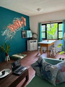 a living room with a couch and a table with a laptop at Hostel Casa Lion - Shared room in Búzios +7 photos
