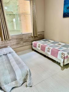 a bedroom with two beds and a window at Casa lazer Atafona in São João da Barra +29 photos