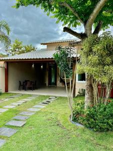 a house with a tree in front of it at Casa lazer Atafona in São João da Barra
