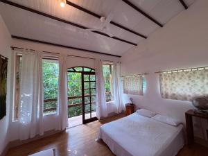 a bedroom with a bed and two windows and a bed sidx sidx sidx at Casa Amarela, Refúgio na natureza Rota do vinho in São Roque