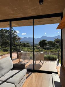 a living room with a couch and glass doors at Casa Cedro in Espera Feliz