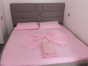 a pink bed with a pink bow on it at Guest House Begaj in Orikum