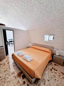 Un dormitorio con una cama y una pared de ladrillo. en C'era una volta, en Martina Franca