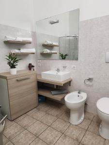 un bagno con lavandino, water e specchio di Al civico 10 a Robecchetto con Induno