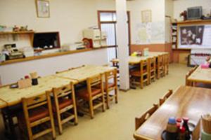 ein Klassenzimmer mit Tischen und Stühlen in einem Klassenzimmer in der Unterkunft Mimatsuso in Izumi-Sano