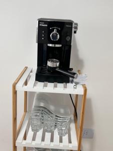 Una cafetera en un estante con gafas. en Excelente Apartamento en calle Moldes, en Buenos Aires