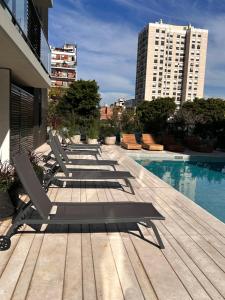 una fila de tumbonas en una terraza cerca de una piscina en Excelente Apartamento en calle Moldes, en Buenos Aires