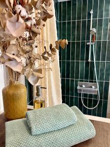 a bathroom with a shower and a vase with flowers at Le Cottage des Chalands in Saint-Georges-sur-Cher
