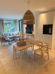 a living room with a table and a couch at Beachfront apartment with private swimming dock in Asker