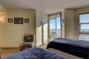 a bedroom with a bed and a chair and a window at St. Regis 3105 - Adorable Oceanfront Condo in Chadwick Acres