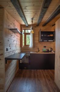 una cocina en una cabaña de madera con una mesa y una ventana en Quiet City Apartments, en Žabljak