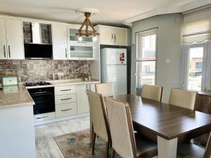 a kitchen with a wooden table and a dining room at Tripleks Özel Havuzlu Lüks Villa in Mersin