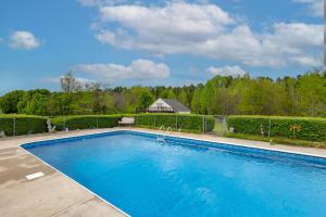 a large blue swimming pool with a house in the background at Over Garage Apartment Studio in Lincolnton