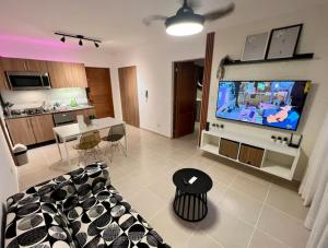 Tonysh Home في Los Perolejos: غرفة معيشة مع أريكة وتلفزيون بشاشة كبيرة