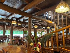 a dining room with wooden tables and chairs and lights at Arca Tayrona Hotel & Restaurant in Santa Marta