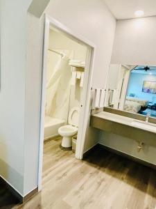 Un baño con inodoro y un espejo grande. en Americas Best Value Inn La Porte, en La Porte