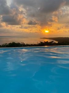 乌维塔Ballena Paraíso Lodge的一座享有日落美景的游泳池