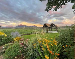 a garden with a gazebo with mountains in the background at Daisy Glamping Tent at Zenzen Gardens in Paonia