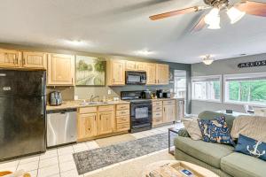 Una sala de estar con un sofá y una cocina. en 2 Fire Pits and Lake Access Cozy Mecosta Getaway!, en Mecosta
