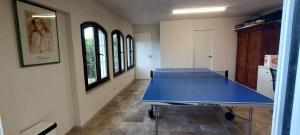 a blue ping pong table in a room with windows at Maison vue mer a 5 min de MONACO in Roquebrune-Cap-Martin