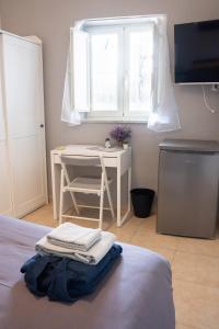 a bedroom with a bed with a desk and a television at La Julienne AC in Naples