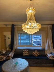 MARINA Agadir flat في أغادير: ثريا وطاولة في غرفة المعيشة