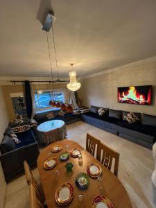 MARINA Agadir flat في أغادير: غرفة معيشة مع طاولة طعام ومدفأة