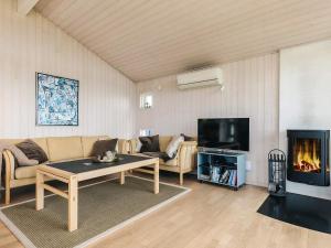 a living room with a couch and a fireplace at 6 person holiday home in Karrebæksminde-By Traum in Karrebæksminde