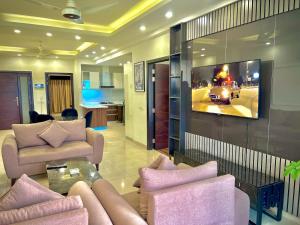 Una sala de estar con un televisor en la pared. en Sky Heights Luxury Apartments Facing Centaurus Mall Islamabad, en Islamabad
